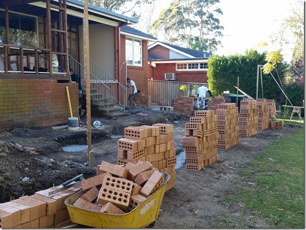 Wheelbarrow transports bricks from from lawn to the rear